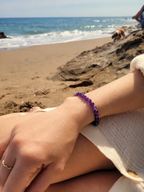 Bracelet en améthyste naturelle 6 mm porté au poignet en bord de mer