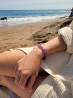 Bracelet en améthyste naturelle 8 mm porté au poignet en bord de mer