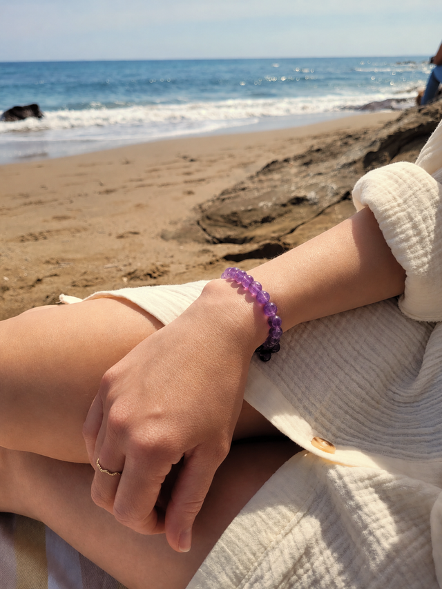 Bracelet en améthyste naturelle 8 mm porté au poignet en bord de mer