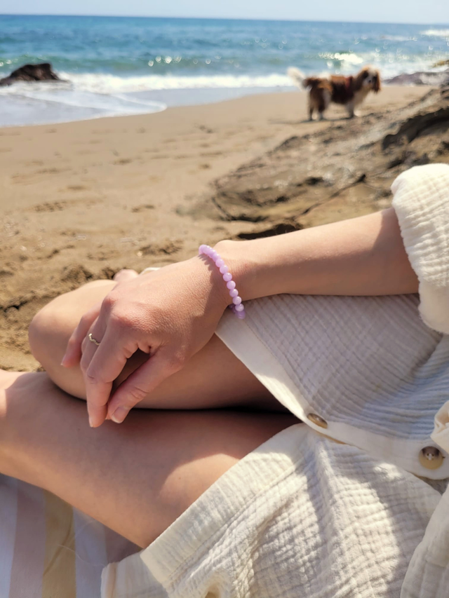 Bracelet en améthyste lavande naturelle 6 mm porté au poignet en bord de mer