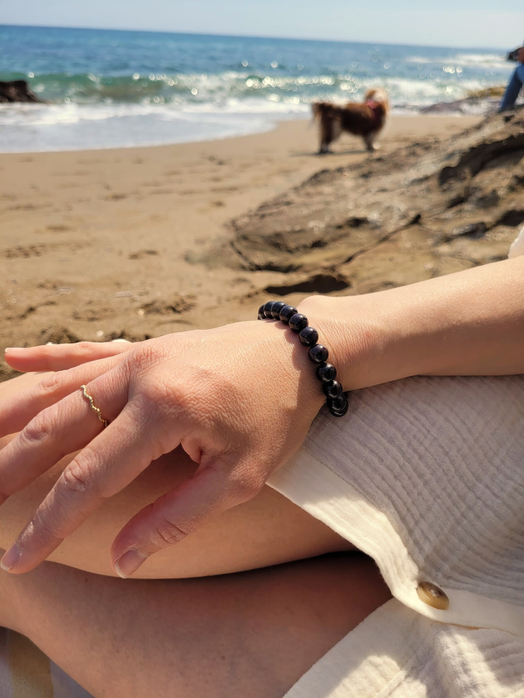 Bracelet en grenat naturel 8 mm porté au poignet en bord de mer