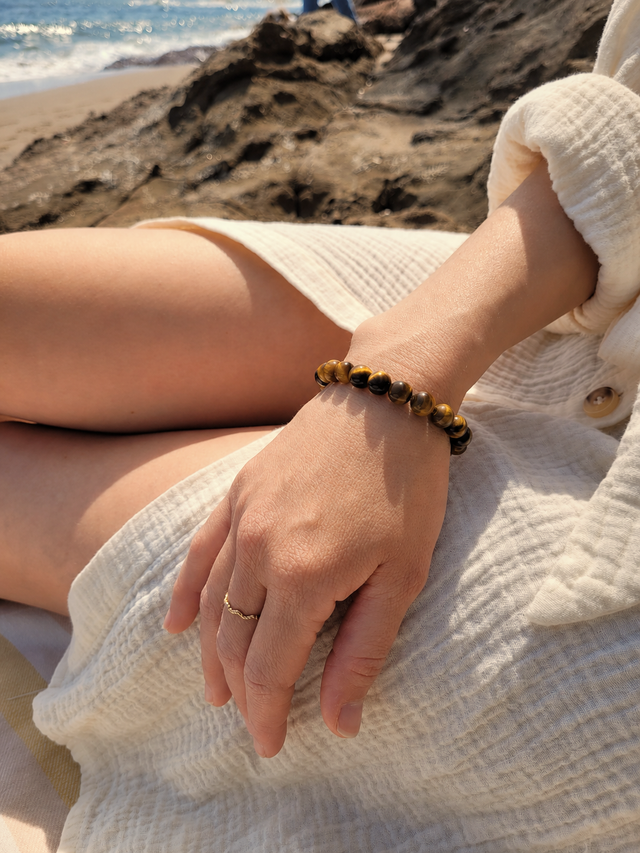 Bracelet en œil de tigre naturel 8 mm porté au poignet en bord de mer